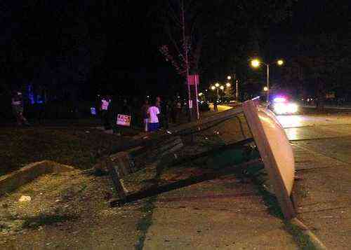 An overturned bus shelter lies on the ground after dozens of people protested following the fatal shooting of a man in Milwaukee, Saturday, Aug. 13, 2016. A crowd of protesters skirmished with police Saturday night in the Milwaukee neighborhood where an officer shot and killed a man after a traffic stop and foot chase earlier in the day, setting fire to a police car and torching a gas station. (AP Photo/Gretchen Ehlke)